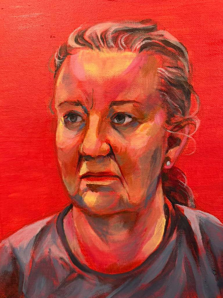 Bust portrait of a middle-aged white woman with blue eyes and graying brown hair in a loose ponytail. The colors are warm and unrealistically vibrant. She is wearing a gray crewneck t-shirt and looking to the left with a serious expression. The background is solid, bright red.